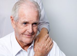 Stariji čovek drži ruku žene